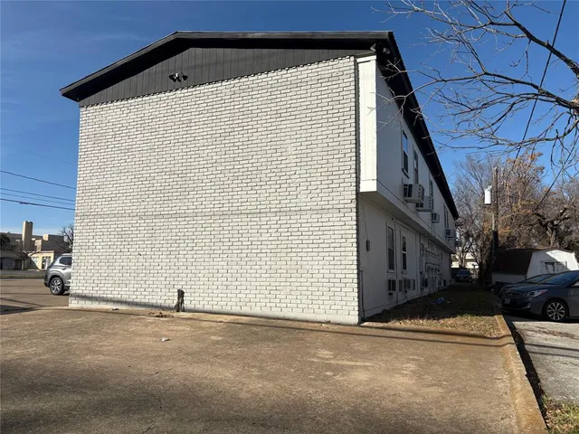 a backyard of a house with table and chairs under an umbrella