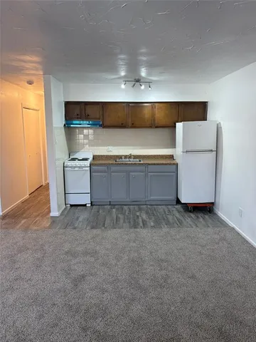 a kitchen with a refrigerator and white cabinets