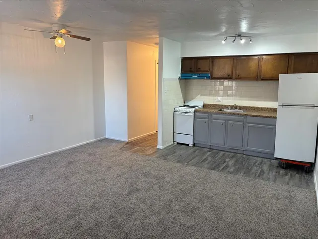 a view of kitchen and empty room with windows