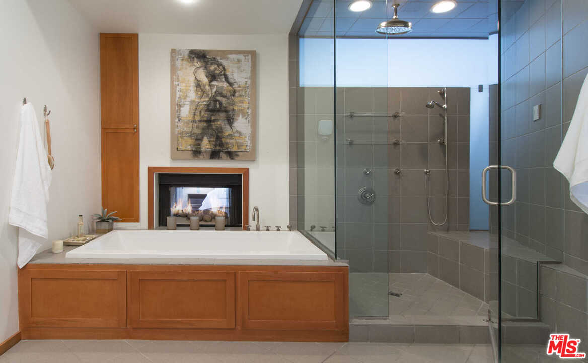 8027 Briar Summit Drive Los Angeles, CA 90046 - Photo 33 of 43 a spacious bedroom with a bed and a fireplace