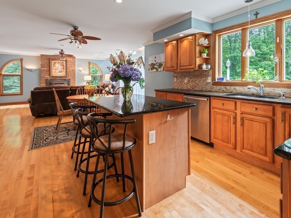 9 Santom Street Auburn, MA 01501 - Photo 3 of 42 a dining hall with stainless steel appliances granite countertop a stove top oven a dining table and chairs with wooden floor