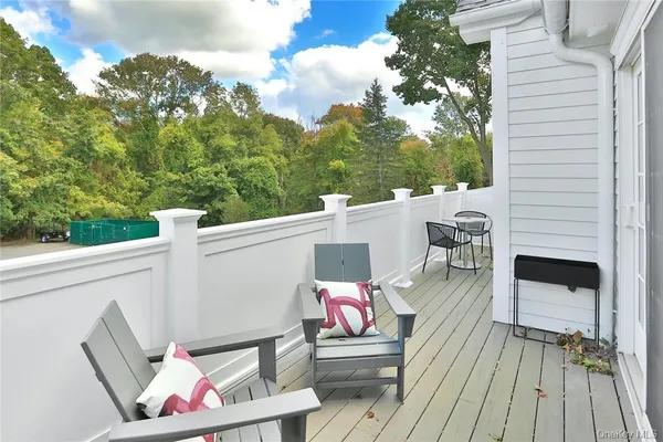a terrace of a house with wooden floor and outdoor seating