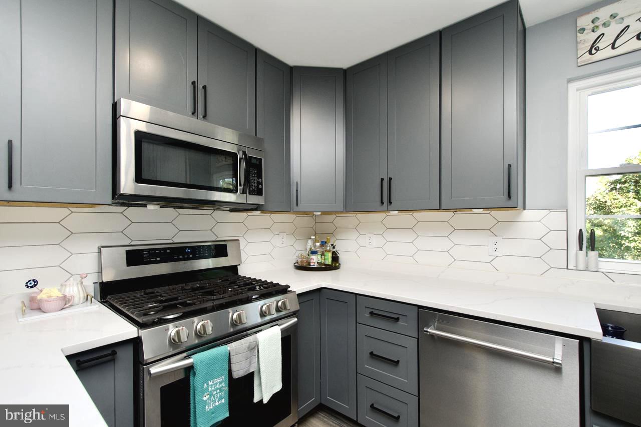 22908 Regent Terrace Sterling, VA 20166 - Photo 11 of 31 a kitchen with stainless steel appliances a stove microwave and sink