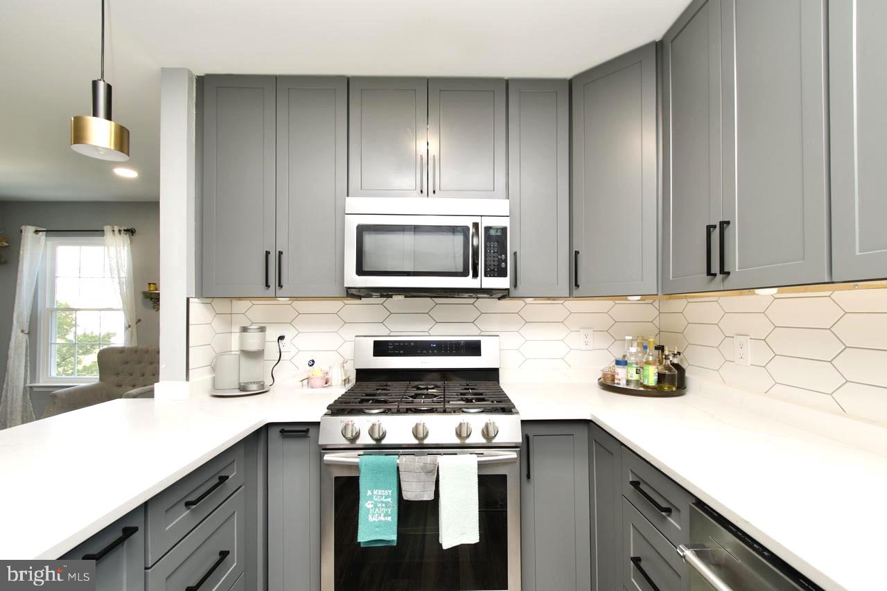 22908 Regent Terrace Sterling, VA 20166 - Photo 12 of 31 a kitchen with a sink stove and cabinets