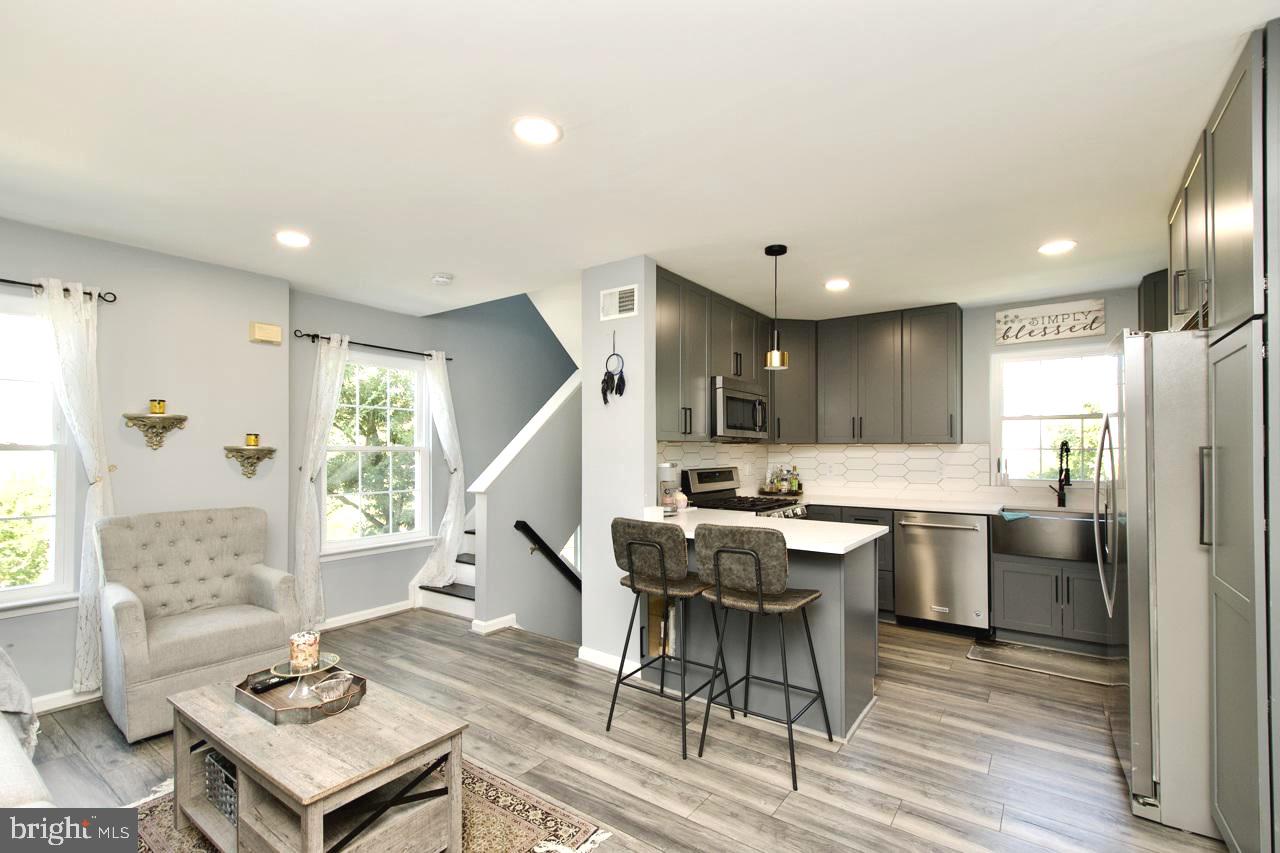 22908 Regent Terrace Sterling, VA 20166 - Photo 13 of 31 a kitchen with a table chairs refrigerator and cabinets