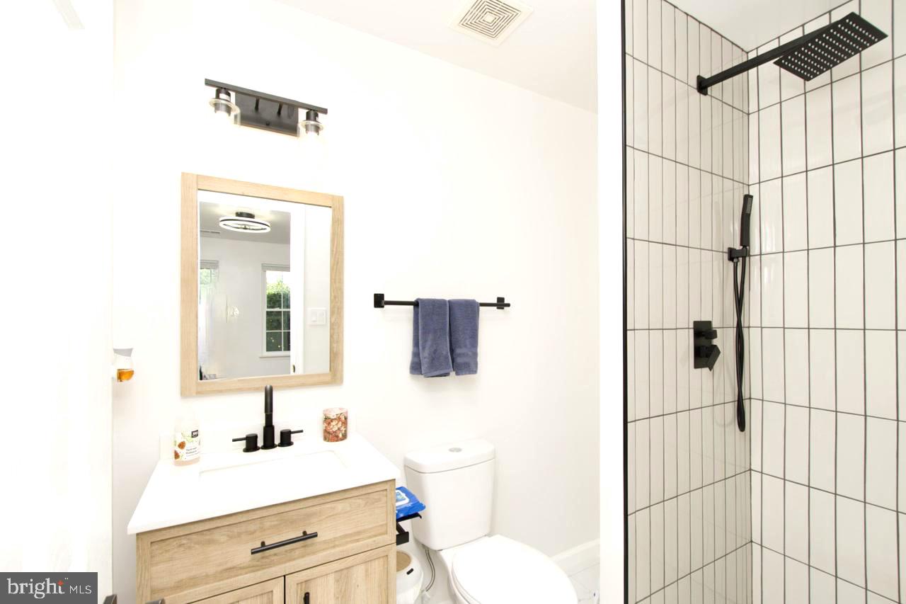 22908 Regent Terrace Sterling, VA 20166 - Photo 23 of 31 a bathroom with a sink vanity mirror and shower