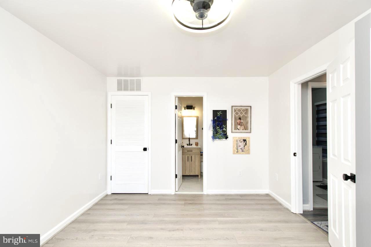 22908 Regent Terrace Sterling, VA 20166 - Photo 27 of 31 a view of a room with wooden floor and white walls