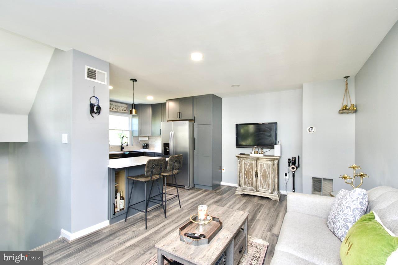 22908 Regent Terrace Sterling, VA 20166 - Photo 7 of 31 a living room with stainless steel appliances furniture a flat screen tv and a refrigerator