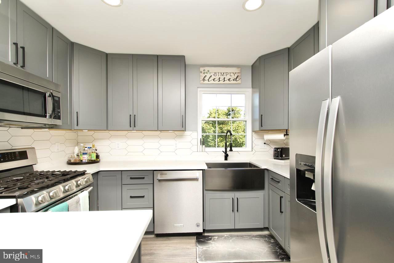 22908 Regent Terrace Sterling, VA 20166 - Photo 8 of 31 a kitchen with stainless steel appliances a sink stove and refrigerator