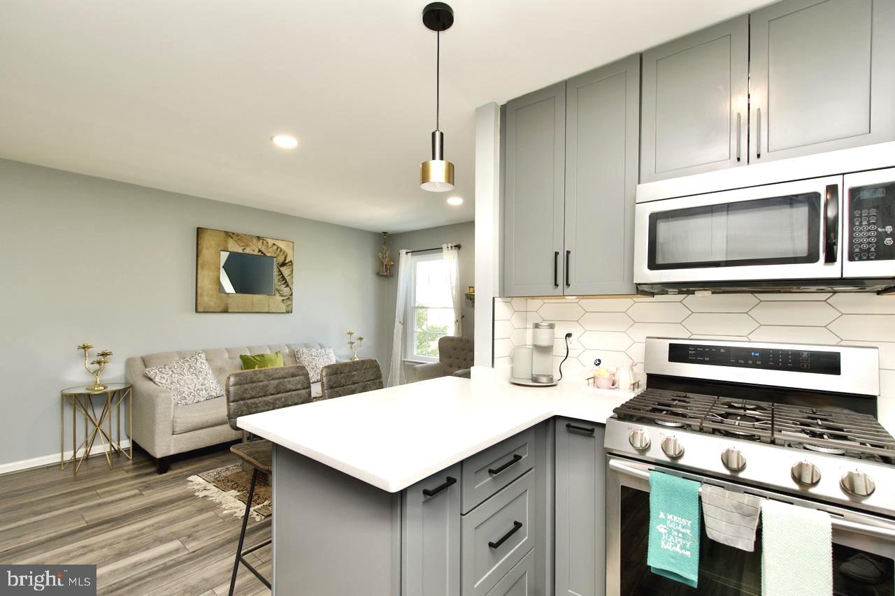 22908 Regent Terrace Sterling, VA 20166 - Photo 9 of 31 a kitchen with a stove cabinets and wooden floor