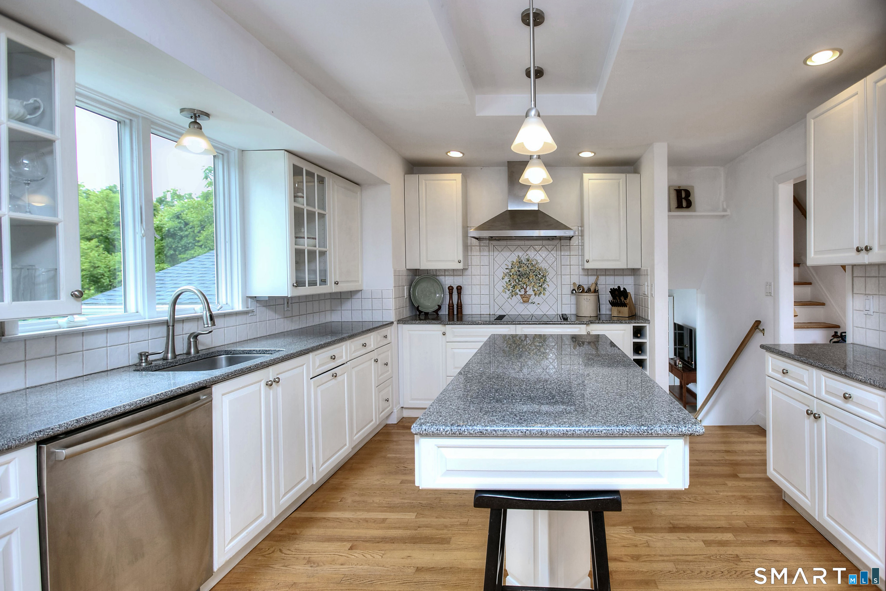 324 Ridge Road Orange, CT 06477 - Photo 11 of 38 a kitchen with stainless steel appliances granite countertop a sink a counter space wooden floor and a window