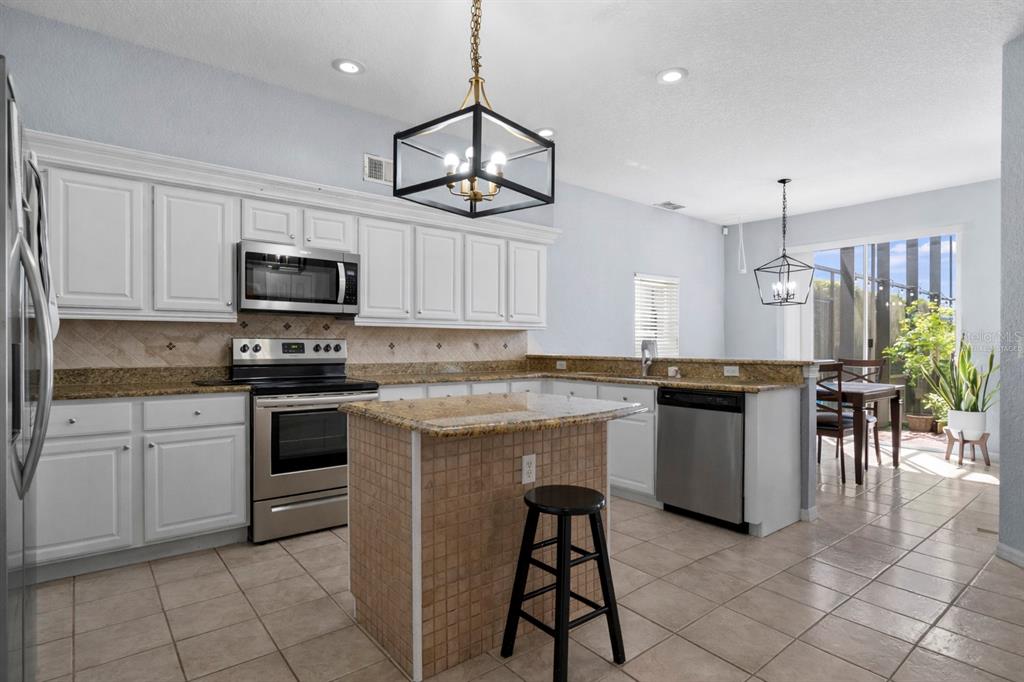 2264 Stone Cross Circle Orlando, FL 32828 - Photo 12 of 45 a kitchen with kitchen island granite countertop a sink counter top space appliances and cabinets