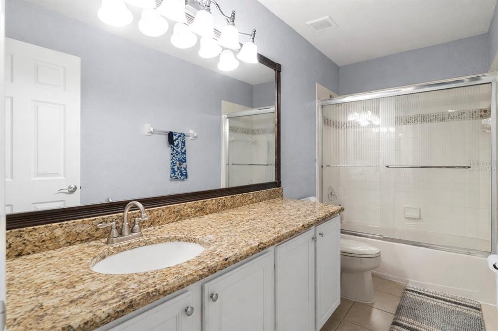 2264 Stone Cross Circle Orlando, FL 32828 - Photo 24 of 45 a bathroom with a granite countertop sink a toilet and shower