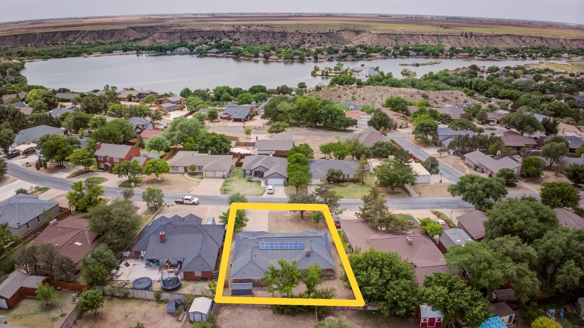 an aerial view of residential houses with outdoor space and lake view
