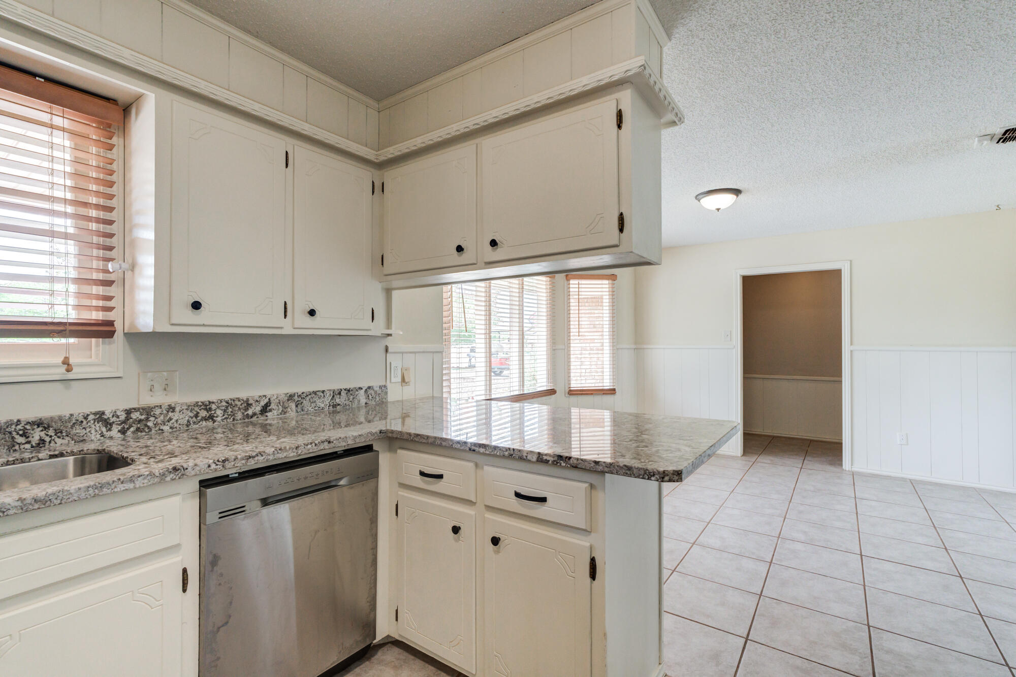 26 Highland Drive Ransom Canyon, TX 79366 - Photo 19 of 53 a kitchen with granite countertop white cabinets and white appliances