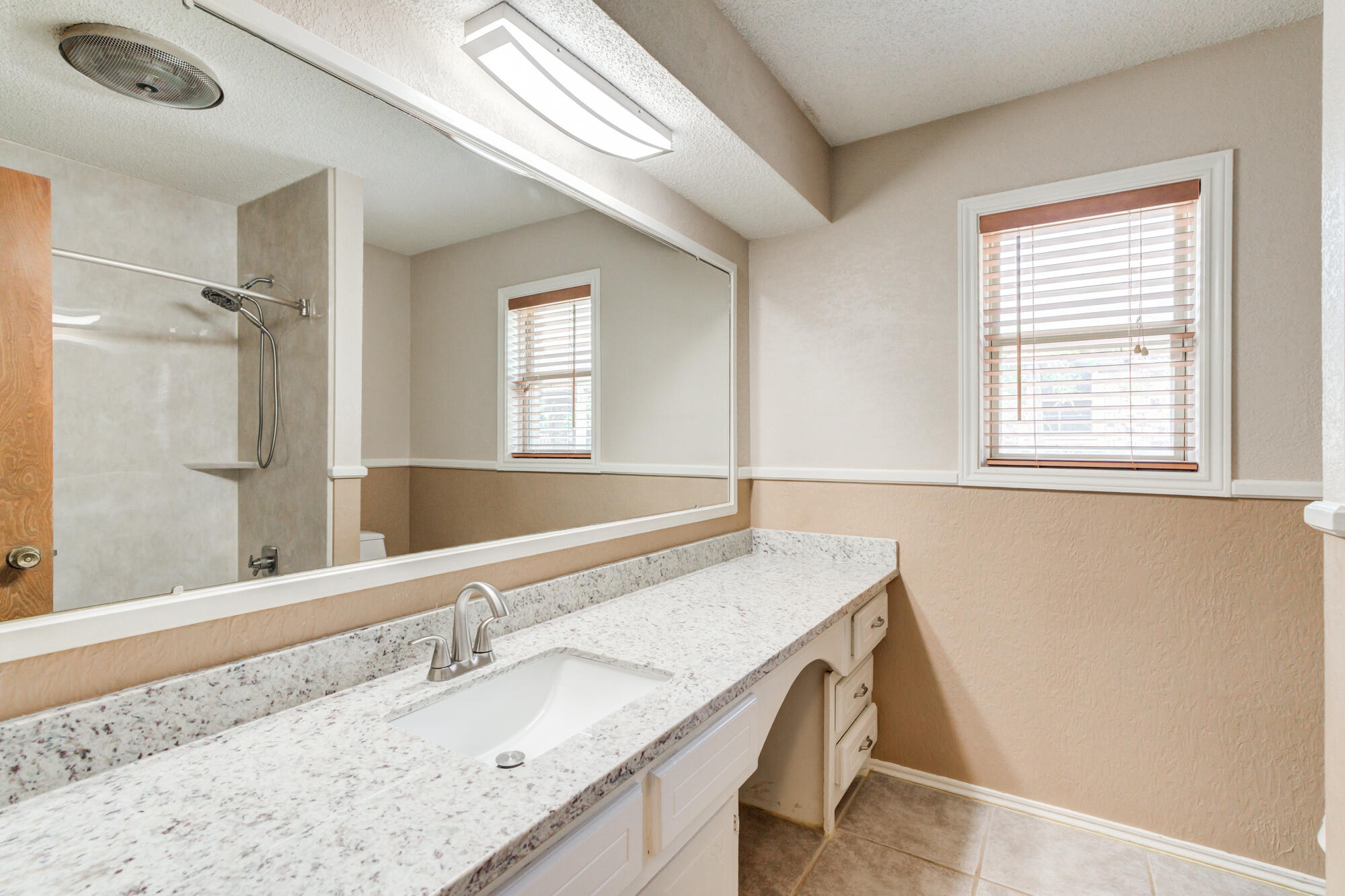 26 Highland Drive Ransom Canyon, TX 79366 - Photo 36 of 53 a bathroom with a granite countertop sink and a mirror