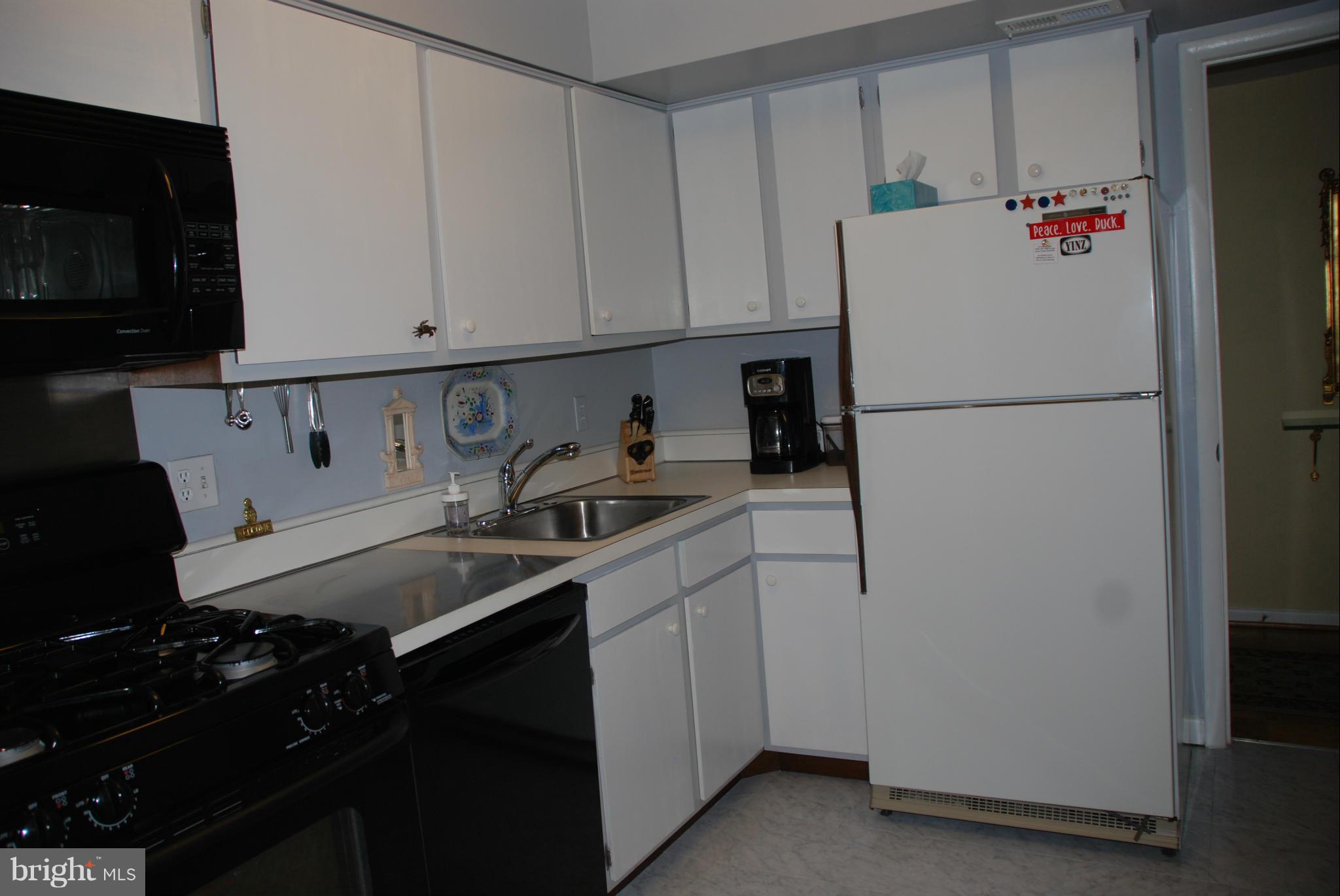 107 Cross Keys Road, Unit R107E Baltimore, MD 21210 - Photo 5 of 14 a kitchen with refrigerator a stove a sink and cabinets