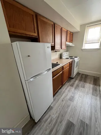a kitchen with sink a refrigerator and window