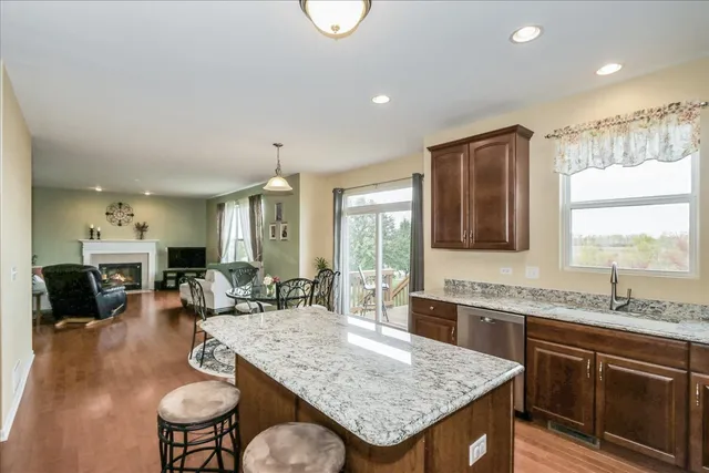 a kitchen with granite countertop a table chairs sink and cabinets