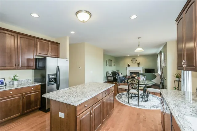 a kitchen with stainless steel appliances granite countertop sink stove refrigerator and cabinets