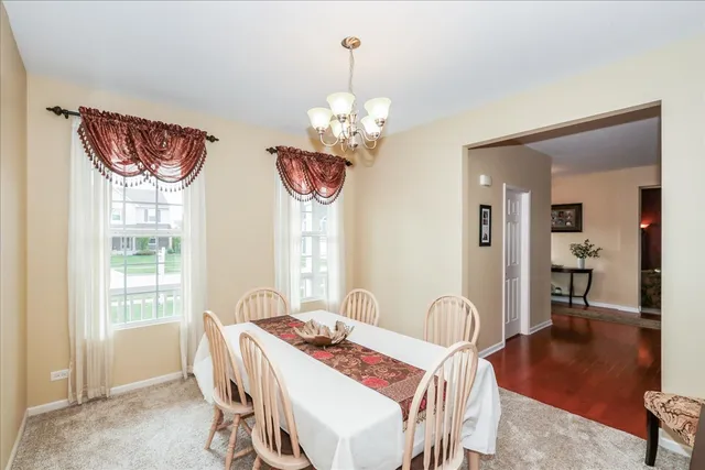 a view of a dining room with furniture a chandelier and wooden floor