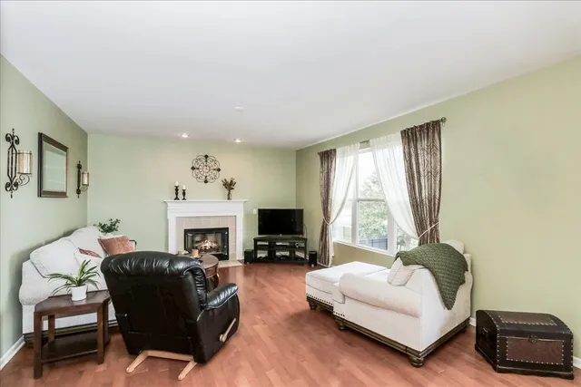 a living room with furniture a fireplace and a flat tv screen next to a window