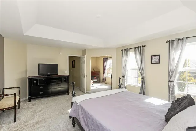 a bedroom with a bed and a flat tv screen on dresser