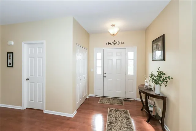 a view of entryway with a chandelier fan and wooden floor