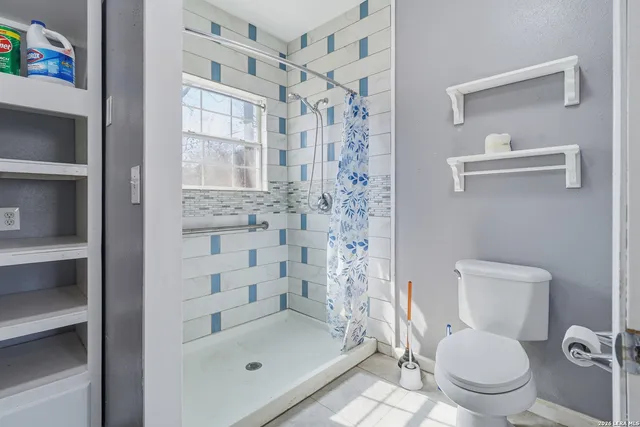 a bathroom with a toilet and a shower