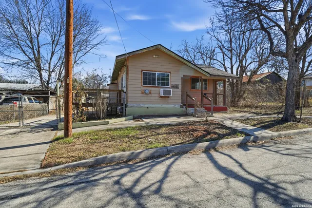 a view of a yard in front of a house with a large tree