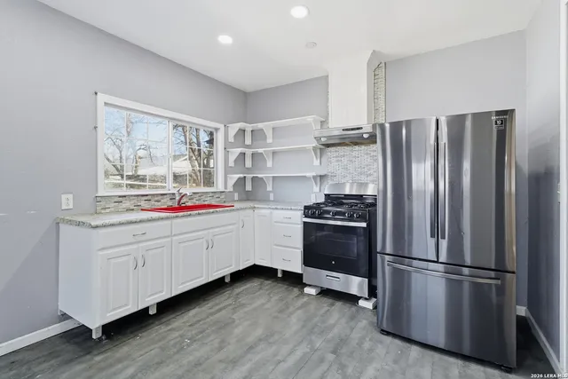 a kitchen with stainless steel appliances a refrigerator sink and cabinets