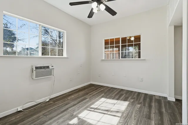 a view of empty room with wooden floor and fan
