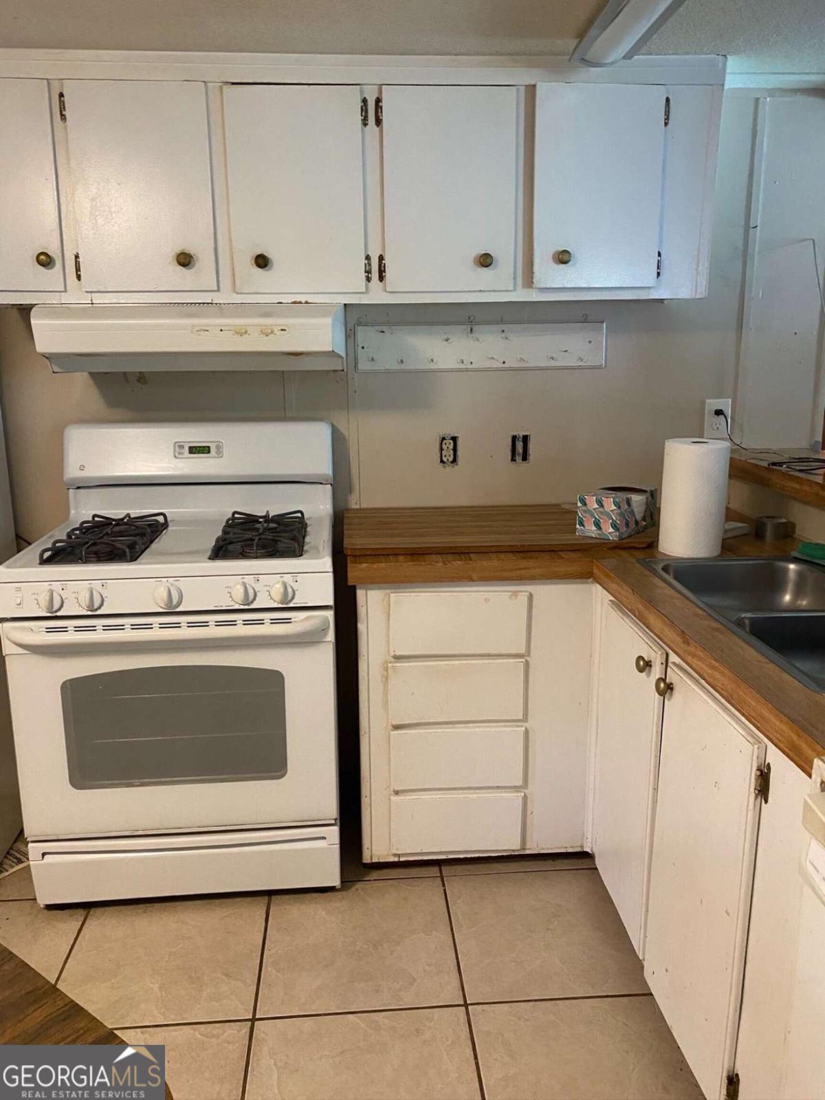 132 Fourth Street Southwest Milledgeville, GA 31061 - Photo 5 of 6 a kitchen with granite countertop white cabinets and appliances
