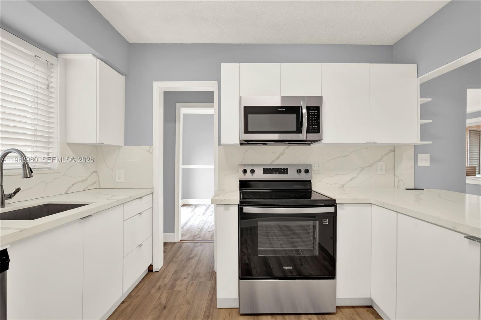 2001 Southwest 37th Avenue Miami, FL 33145 - Photo 10 of 31 a kitchen with cabinets stainless steel appliances and wooden floor
