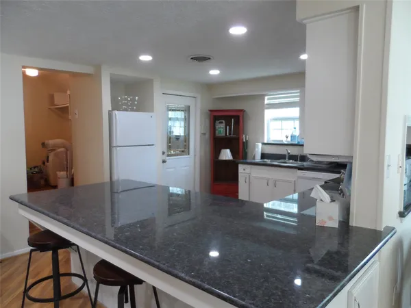 a kitchen with stainless steel appliances granite countertop a stove refrigerator and cabinets