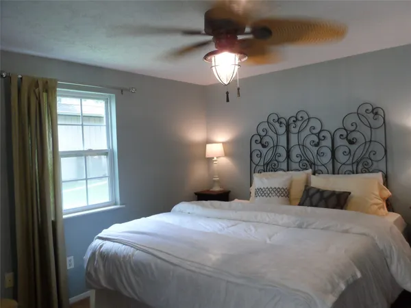 a bedroom with a bed and a window