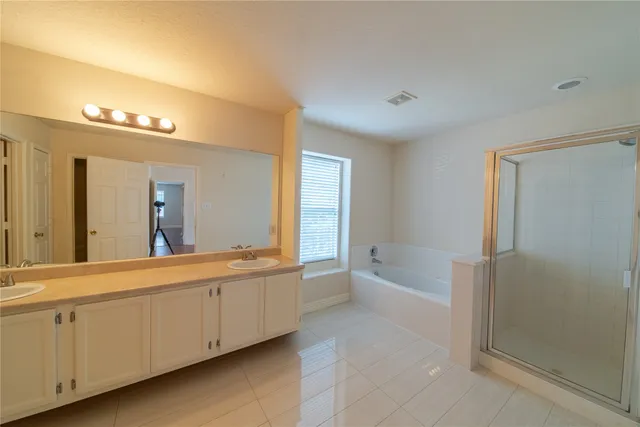 a spacious bathroom with a bathtub sink and mirror