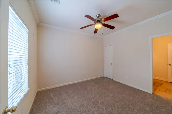 a view of a room with a ceiling fan and a window