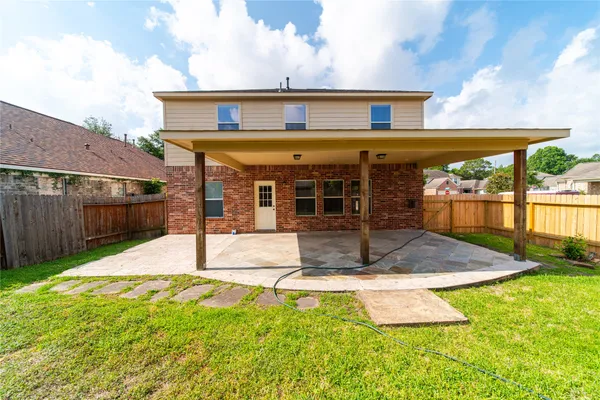 a view of a house with floor to ceiling windows and a yard