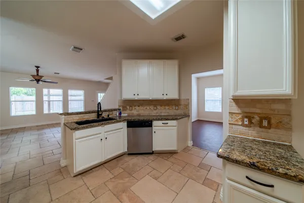 a large kitchen with granite countertop a stove sink and cabinets