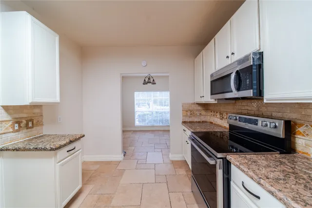 a kitchen with granite countertop a stove and a sink