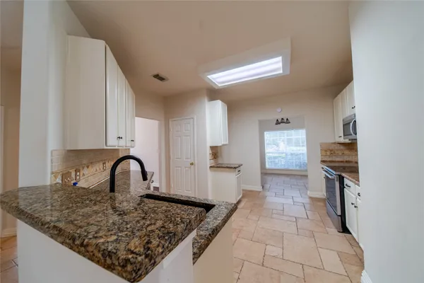a kitchen with a sink a stove and cabinets