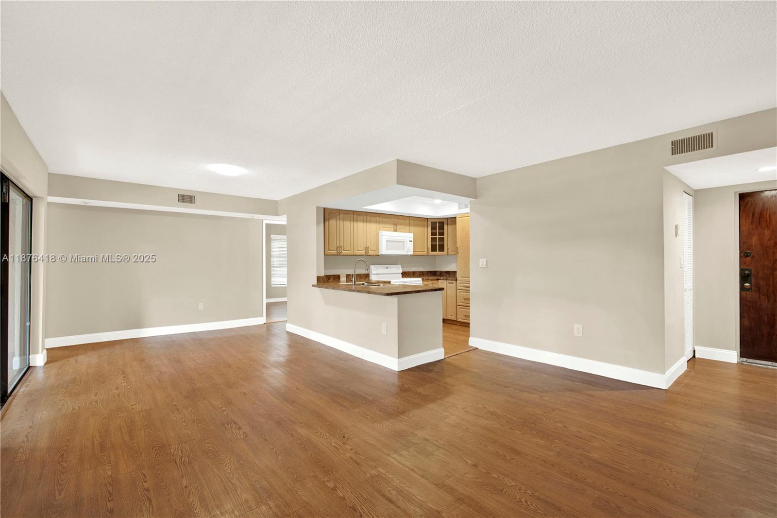 a view of a kitchen with a sink and a refrigerator