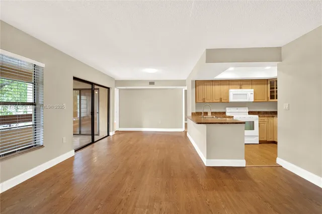 a view of a kitchen with wooden floor and a window