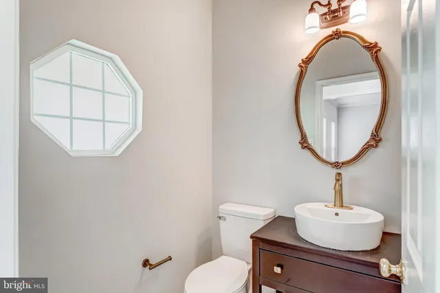 a bathroom with a sink mirror and toilet