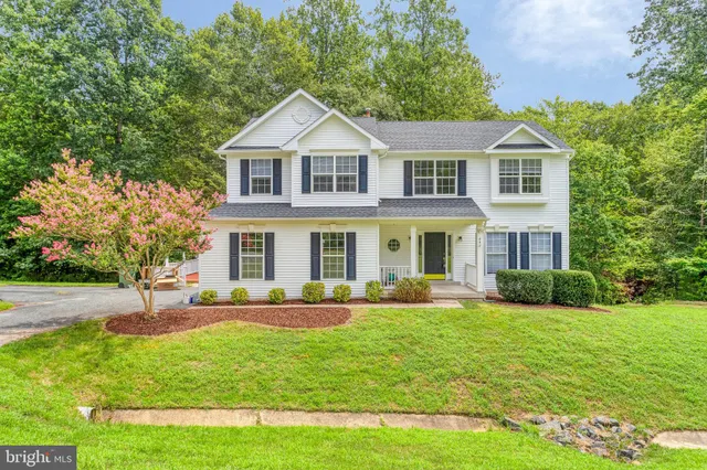 a front view of a house with a yard and trees