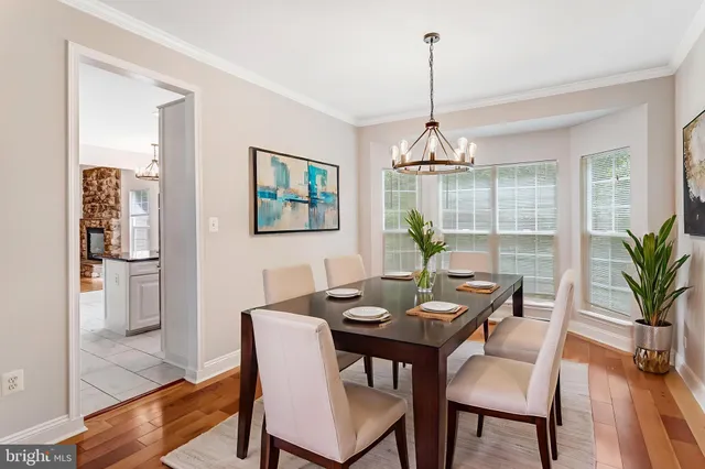 a dining room with furniture a chandelier and wooden floor