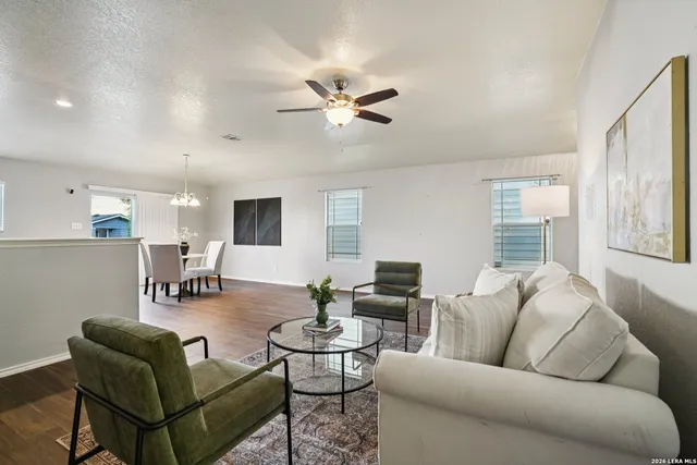 a living room with furniture a ceiling fan and a window