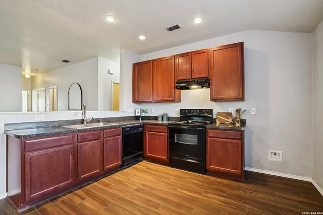 a kitchen with stainless steel appliances granite countertop a stove a sink dishwasher and a refrigerator