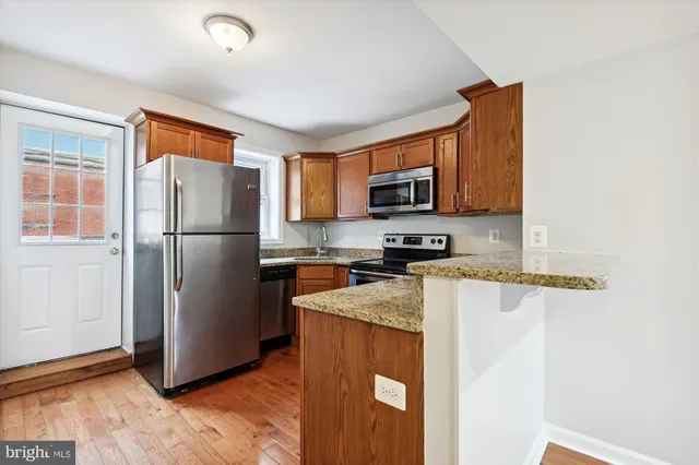 a kitchen with granite countertop a stove top oven microwave and cabinets